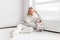 Serene adult woman with dog near radiator in the living room at home