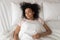 Serene African American woman sleeping in comfortable bed top view