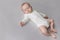 Serene baby in white bodysuit sleeping on double bed