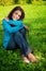 Serene beautiful woman resting on green grass