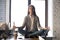 Serene calm business woman sit on office desk meditating