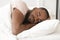 Serene calm young black man sleeping well alone in bed