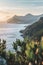 Serene Coastal View of Mountains at Sunset with Verdant Foliage