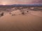 A serene desert landscape with sand dunes under a vast sky