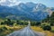 A serene drive through a picturesque countryside road with mountain views.. AI generated.