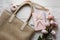 A serene and elegant display featuring a beige tote, pink notebook, and delicate roses