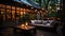 A serene evening setting in a beautifully lit backyard patio. The warm glow of hanging lights and candles creates an inviting