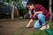 Serene female gardener loosens the ground with a garden rake in the vegetable garden of a country house