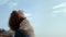 Serene girl standing beach raising face to sunlight closeup. Lady enjoy seascape