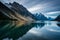 A serene, glassy lake reflecting a cloud-streaked sky and a tranquil mountain range