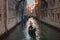 Serene gondola gliding through picturesque Venice canal on a peaceful summer day