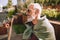 Serene gray-headed mature male skateboarder daydreaming outside