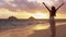 Serene happy woman enjoying nature sunset raising arms to sky enjoying freedom