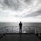 A serene image of a lone figure standing on the deck of a cruise ship