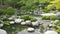 A serene, Japanese Zen garden with meticulously raked gravel and a peaceful pond.