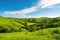 serene landscape with rolling hills, lush greenery and clear blue sky