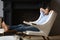 Serene man put feet on footstool relaxing in armchair