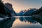 A serene, mirror-like lake reflecting a snow-capped mountain range on a crisp, clear morning