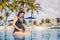 A serene moment captured as a pregnant woman after 40 enjoys a refreshing dip in the pool, embracing the beauty of her