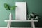 Serene office desk with an empty frame, green branches, potential