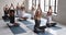 Serene people practising yoga seated cross-legged do meditation together