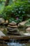 A serene pile of smooth stones balanced in a forest stream with lush greenery in soft focus in the background.