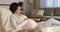 Serene pregnant woman daydreaming while resting on armchair at home