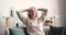 Serene relaxed older woman resting on couch hands behind head