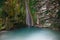 Serene rocks covered with ivy and moss with waterfall flowing down