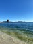 Serene shoreline of a tranquil sea with buildings in the background