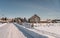 Serene snow-covered landscape with rustic houses in St-Anaclet-de-Lessard, Quebec.