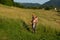 Serene Summer Scene: Farmer Taming the Tall Grass with Trimmer in Sun-Kissed Meadow