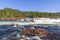 A serene summer view of the Namsen River in Namsskogan, Trondelag, Norway, showcasing a fast-flowing cascade
