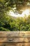 Serene Sunrise Through Lush Foliage with Wooden Tabletop for Product Display, Ideal Nature Backdrop for Advertising