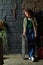 Serene teenage girl in blue jeans and striped stylish shirt standing by wall