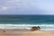 A serene view of Durness Beach, showcasing the tranquil blue waters of the Atlantic meeting the golden sands