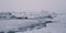 Serene winter landscape with large frozen ice blocks resting on a snowy shoreline