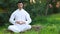 Serene young man doing meditation outdoors