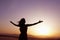 Serene young woman with arms outstretched doing yoga in the desert in China, Silhouette