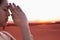 Serene young woman with eyes closed and hands together in prayer pose in the desert in China, side view