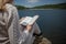 Serenity by the Lake: A Woman Enjoying a Book in Nature