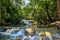 A series of beautiful waterfalls and flat pools in the dense forest of Erawan National park in Thailand