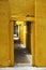 Series of doorways leads deep into an ancient yellow stone building in Hoi An, Vietnam