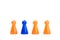 A series of orange game pieces and one different and exceptional blue figure as leader or boss, isolated on a white background