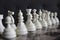 Series of white chess figures focused and unfocused on wooden chessboard as strategy game concept.