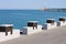 A series of wooden tables with stone benches placed on the edge of the pier of the port of Italy, Europe