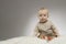 Serious 9 month boy on the white blanket on grey background