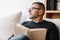 Serious adult unshaven man reading book while resting