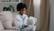 Serious african american kid girl sitting in room on couch in medical uniform pretending to be doctor little child