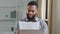 Serious African American man ethnic bearded businessman boss entrepreneur bookkeeper executive in office holding papers